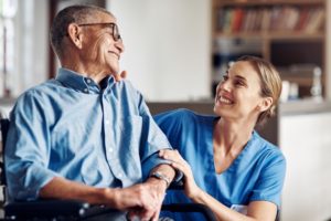 Care worker helping an elderly man.