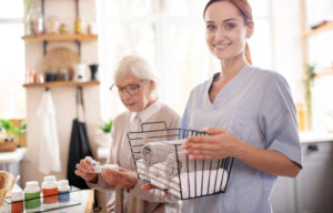 Care Worker aiding elderly woman with laundry and medication